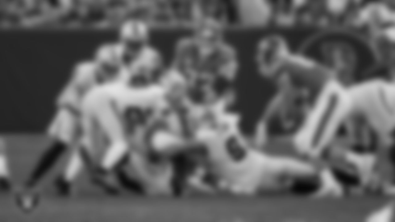 Las Vegas Raiders safety Chris Smith II (29) and defensive end Tyree Wilson (9) make a tackle during the regular season away game against the Denver Broncos at Empower Field at Mile High, Sunday, October 6, 2024, in Denver, Colo.