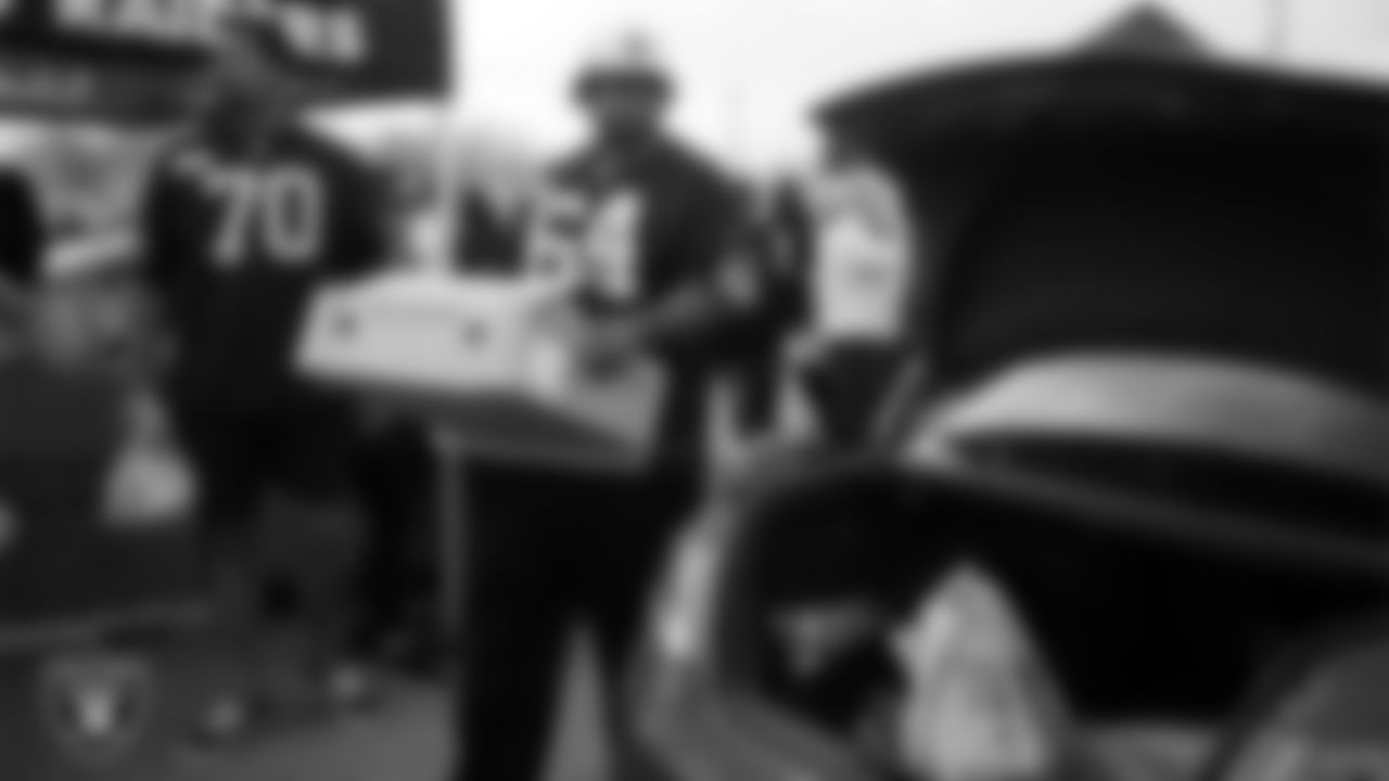 Las Vegas Raiders guard Layden Robinson (64) helps distribute Thanksgiving meals to families during Turkey Time with the O-Line at Allegiant Stadium.