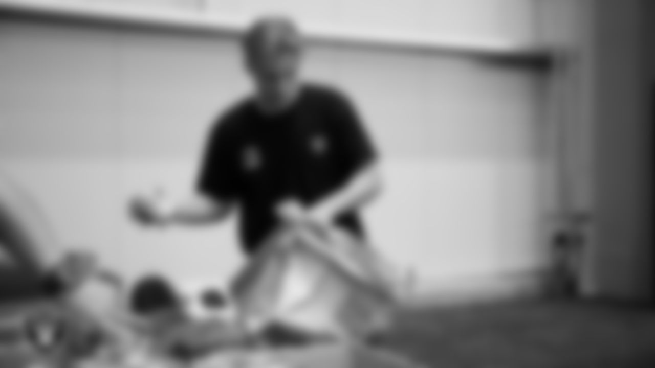 Las Vegas Raiders staff members help pack meals during the Raiders Holiday Meal Packing Party at Intermountain Health Performance Center.