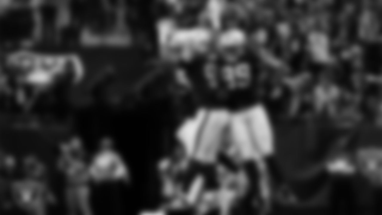 Las Vegas Raiders defensive end Charles Snowden (49), defensive tackle Jonah Laulu (96) and defensive tackle Thomas Booker IV (99) celebrate on the field during the regular season home game against the Tennessee Titans at Allegiant Stadium.