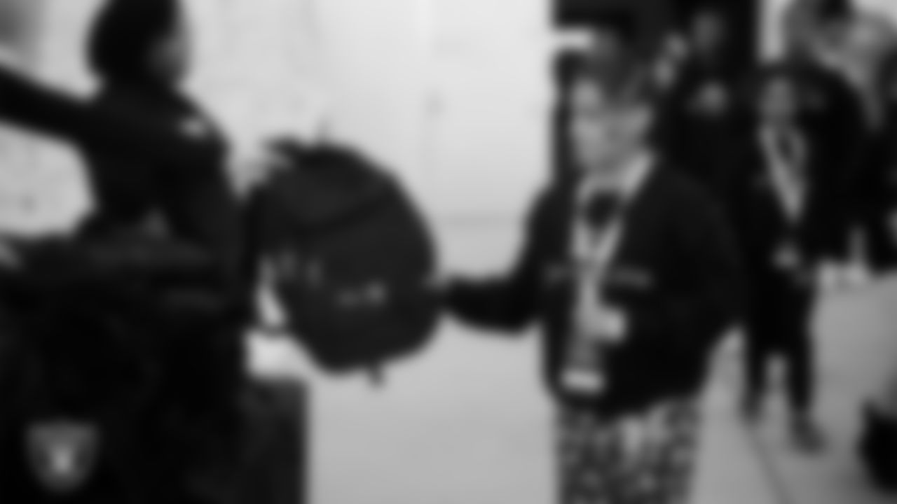 A student receives a backpack during a Raiders Youth Holiday Party at Intermountain Health Performance Center.