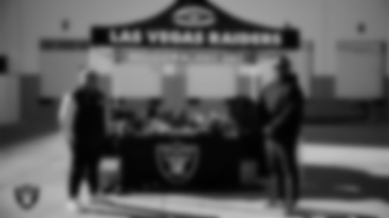 Las Vegas Raiders senior manager of football development Jordan Aguilar poses for a photo with a coach during the Raiders' Equipment Blitz at Intermountain Health Performance Center.