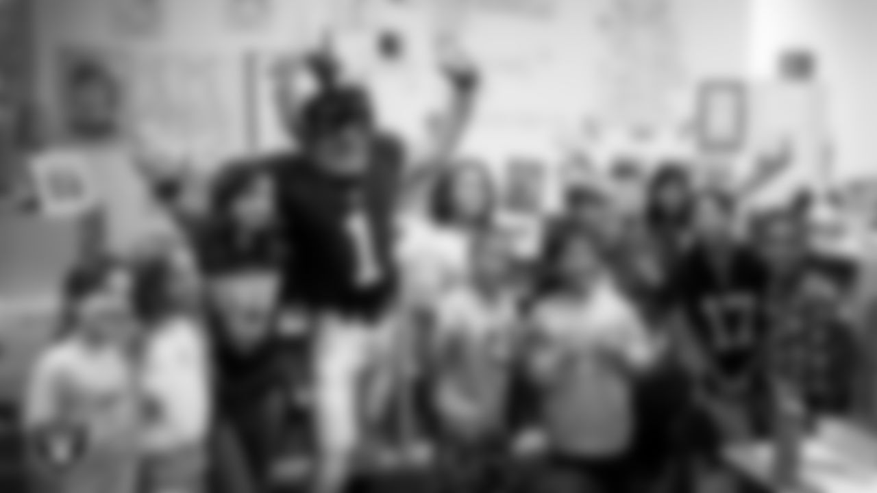 Raider Rusher poses for a photo with students during a 'Lil Raiders Pop-Up at Richard H. Bryan Elementary School.