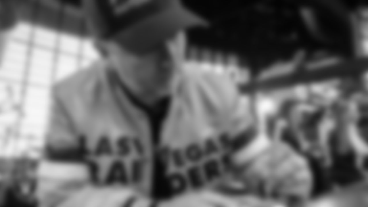 Las Vegas Raiders fan and Guinness World Record holder Brian Fowler signs a plaque for the Al Davis Memorial torch before the Las Vegas Raiders' regular season home game against the Kansas City Chiefs at Allegiant Stadium.