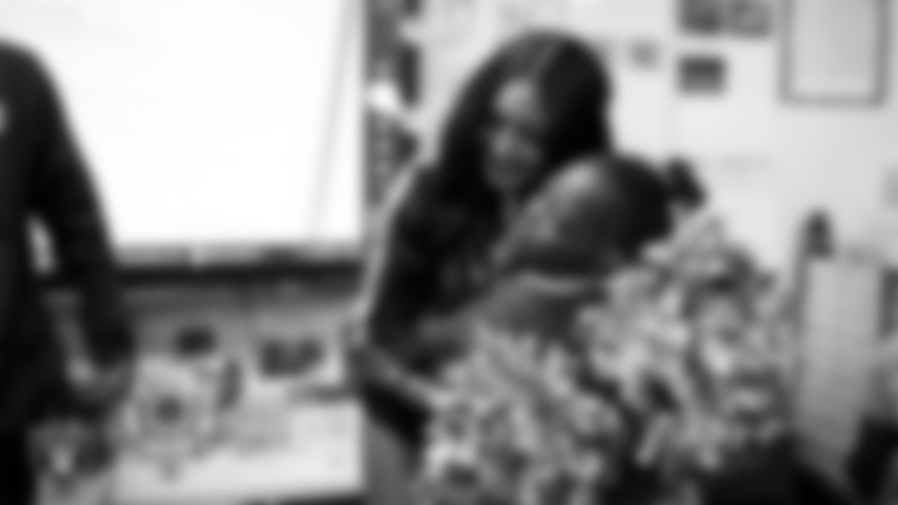 Raiderette Sloane hugs a student during a 'Lil Raiders Pop-Up at Matt Kelly Elementary School.