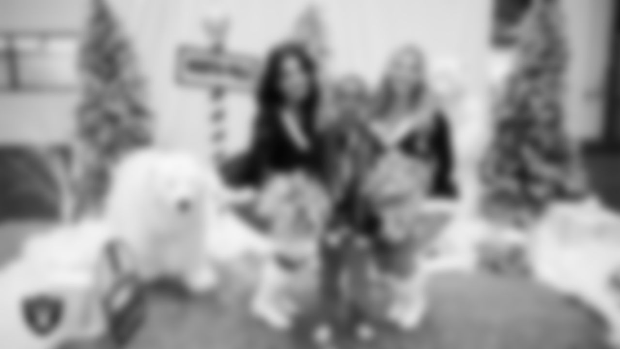 Raiderettes Annalise and Ali pose for a photo with a student during a Raiders Youth Holiday Party at Intermountain Health Performance Center.