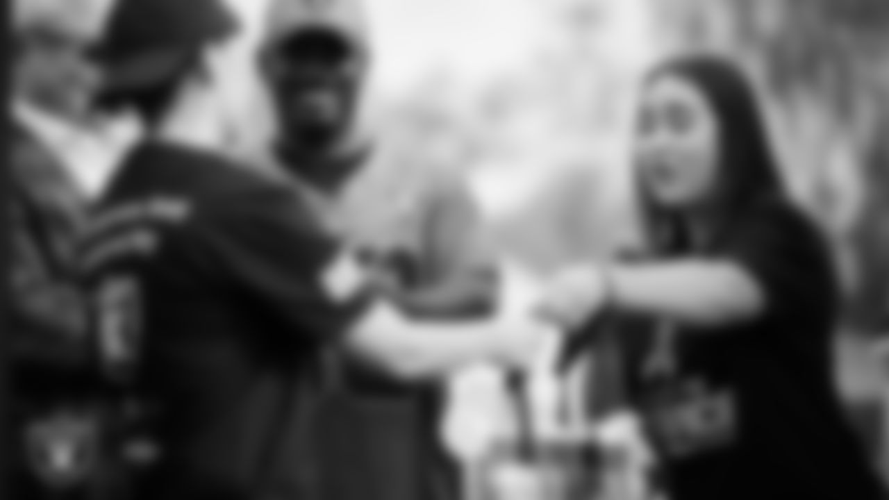 Las Vegas Raiders manager of community relations Shelby Hurd gifts a U.S. VETS veteran Raiders tickets and gear during the Veterans Tailgate in Downtown Las Vegas.