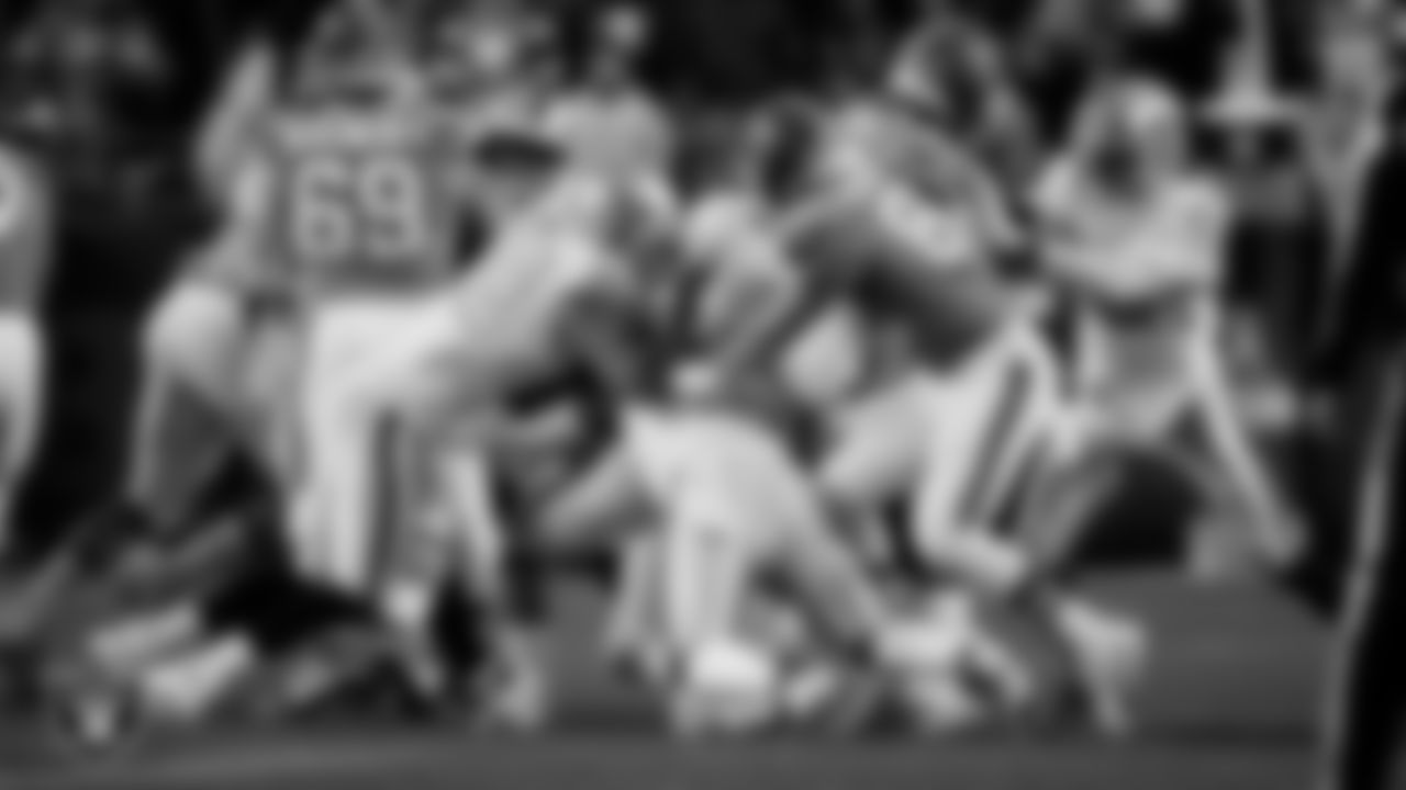Las Vegas Raiders defensive end Maxx Crosby (98) and linebacker Elandon Roberts (52) make a tackle during the regular season away game against the Denver Broncos at Empower Field at Mile High.