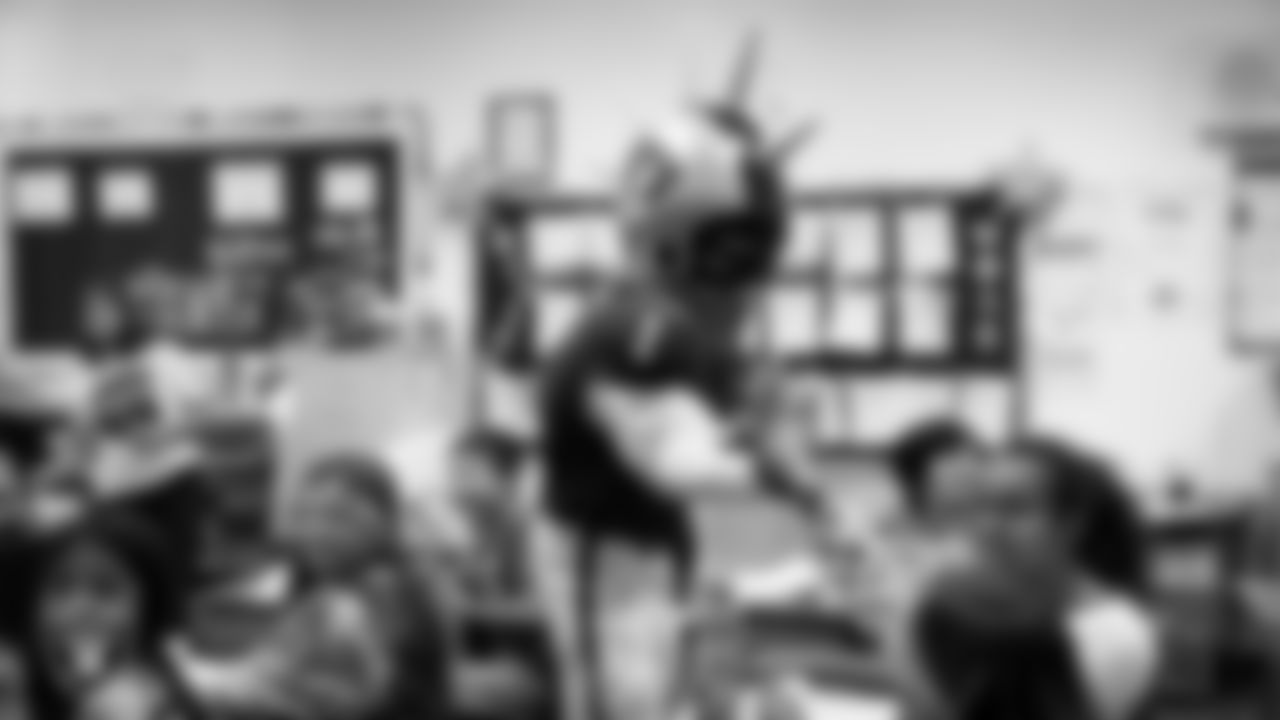 Raider Rusher gives a high-five to a student during a 'Lil Raiders Pop-Up at Richard H. Bryan Elementary School.