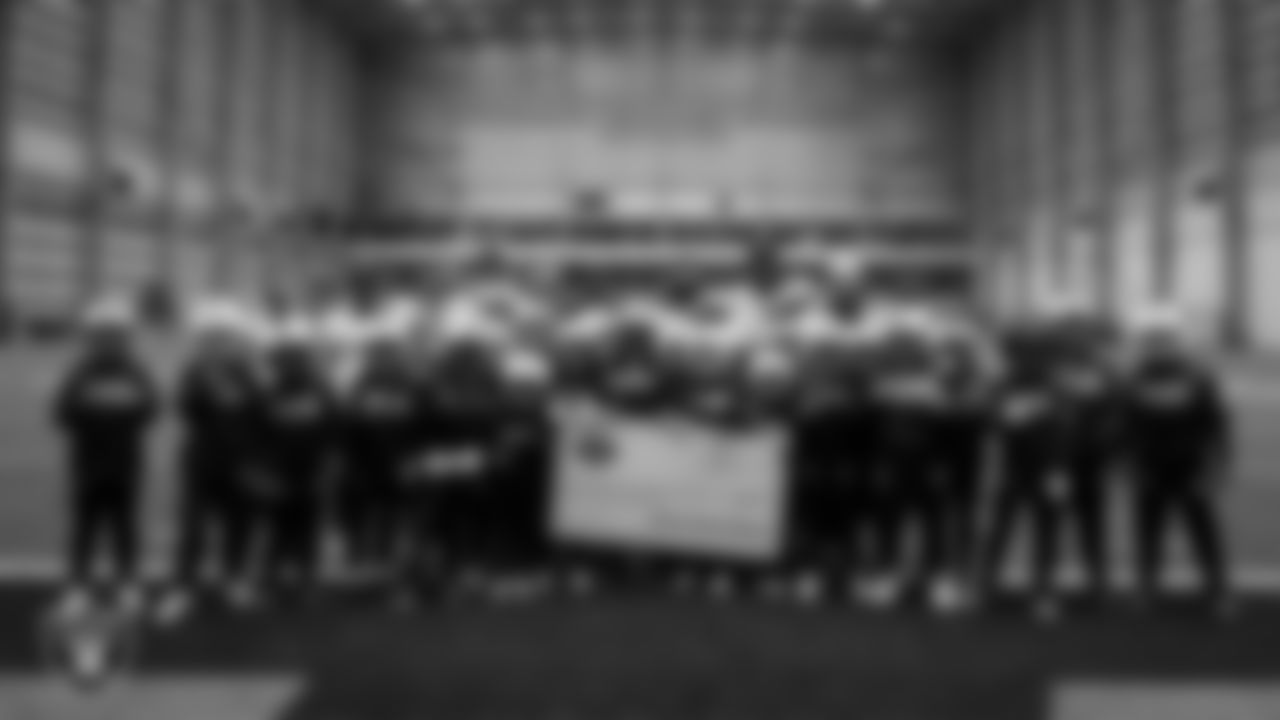 Athletes pose for a photo after receiving a check to go towards their travels for nationals during an open practice at Intermountain Health Performance Center.