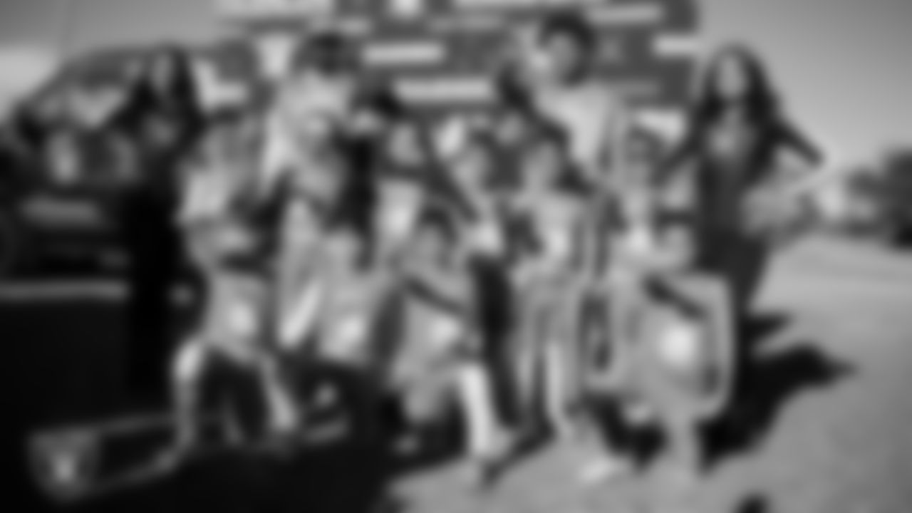 Raiderettes Kylee and Sloane pose for a photo with athletes during the LEEAP Flag Football Tournament at Desert Breeze Park.