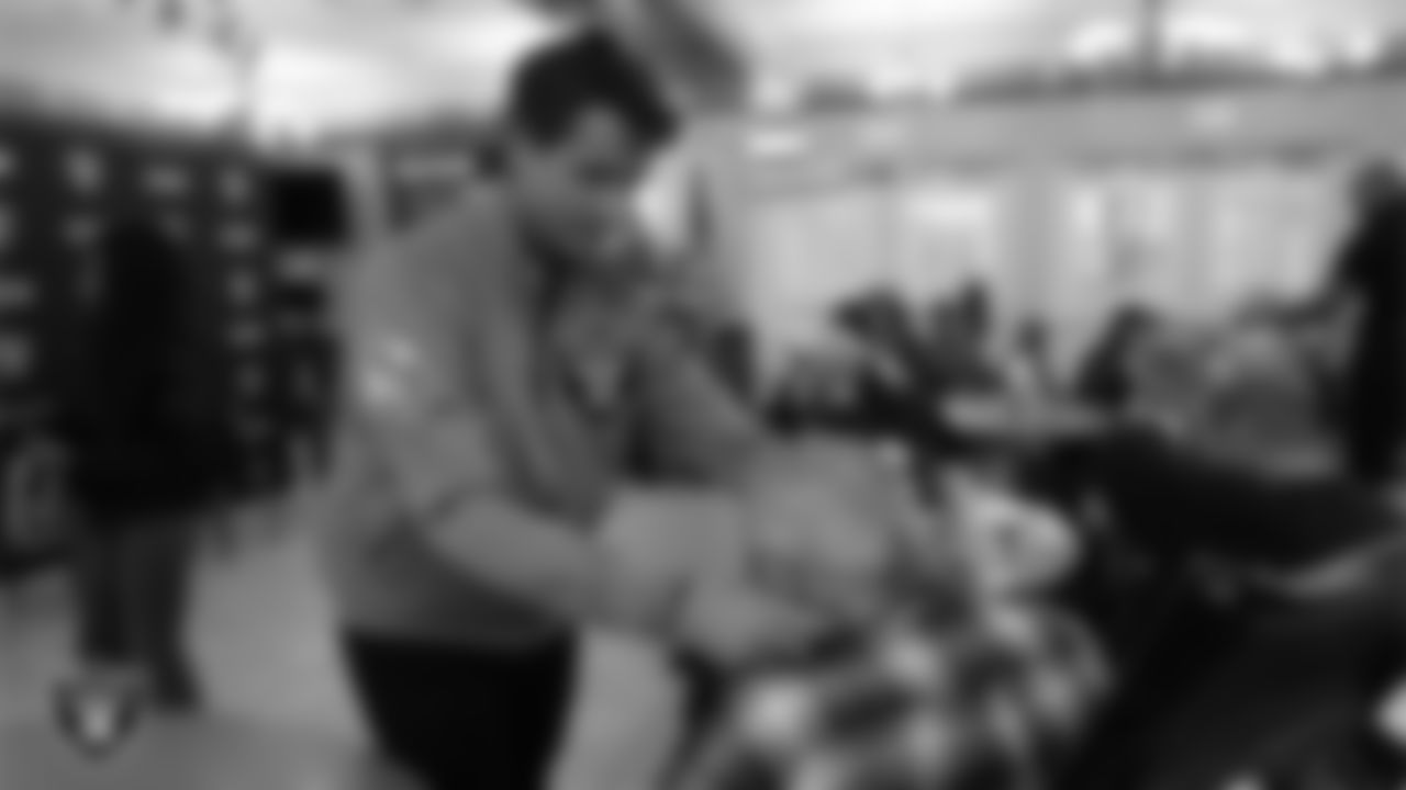 Las Vegas Raiders manager of corporate partnerships activation Austin Crafton hands out Raiders gear to a veteran during the annual Cox Salute to Service Tailgate at Southern Nevada State Veterans Home.