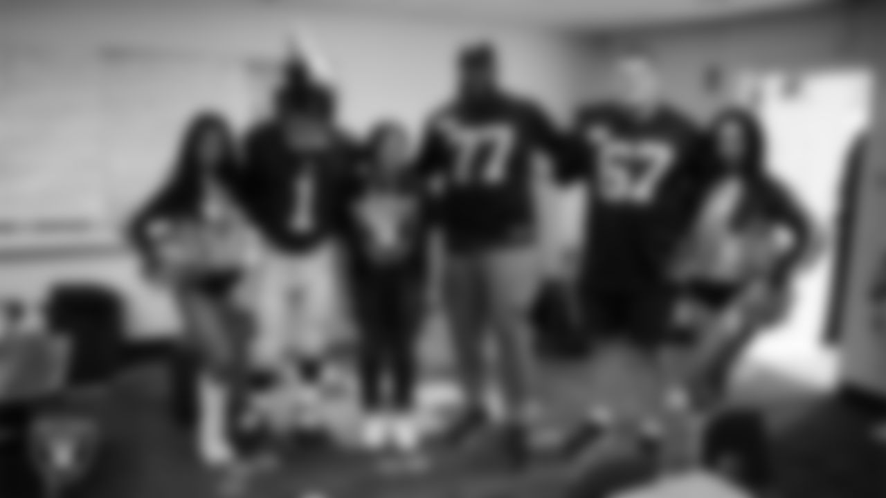 Raiderettes Cierra and Kylee, Raider Rusher and Las Vegas Raiders tackle Thayer Munford Jr. (77) and center Will Putnam (67) pose for a photo with a teacher while celebrating Teacher Appreciation Week at Matt Kelly Elementary School.