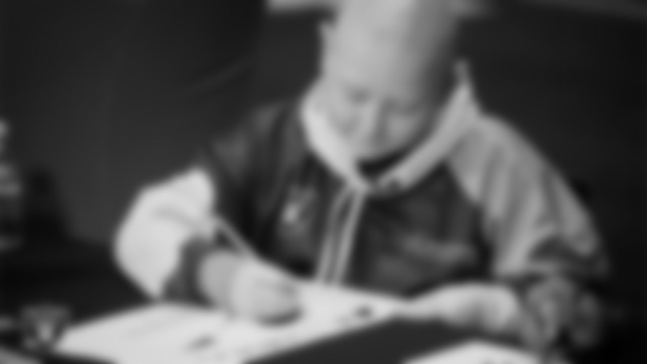 Las Vegas Raiders linebacker Elandon Roberts (52) designs cleats for My Cause My Cleats with Intermountain Children's Health patient Isaak at Intermountain Health Performance Center.