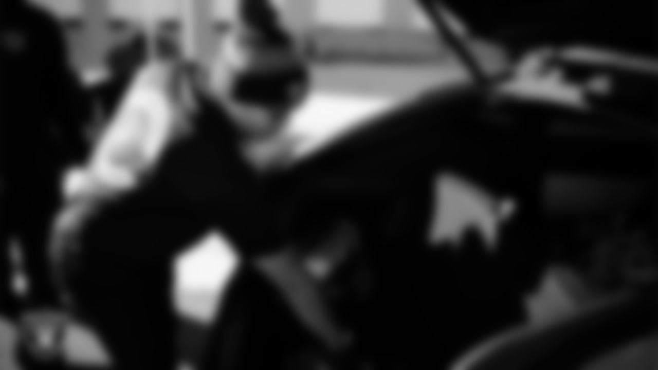 A Las Vegas Raiders ambassador loads equipment into a vehicle during the Raiders' Equipment Blitz at Intermountain Health Performance Center.