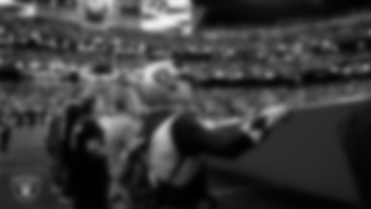 The American flag is displayed by Personal Seat License (PSL) holders on the field during the national anthem before the Las Vegas Raiders' regular season home game against the Denver Broncos at Allegiant Stadium.