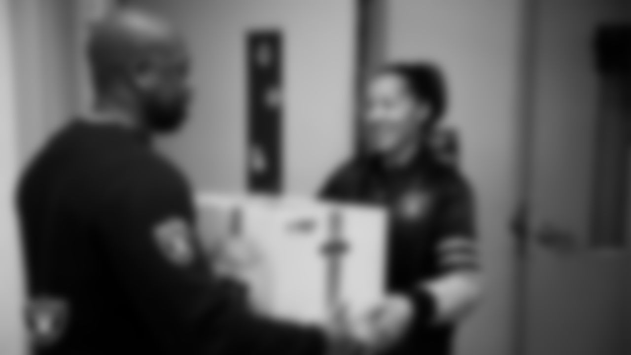 Las Vegas Raiders senior director of football development Myles Hayes presents a teacher with a classroom gift box during a Raiders Spirit Day at Richard H. Bryan Elementary School.