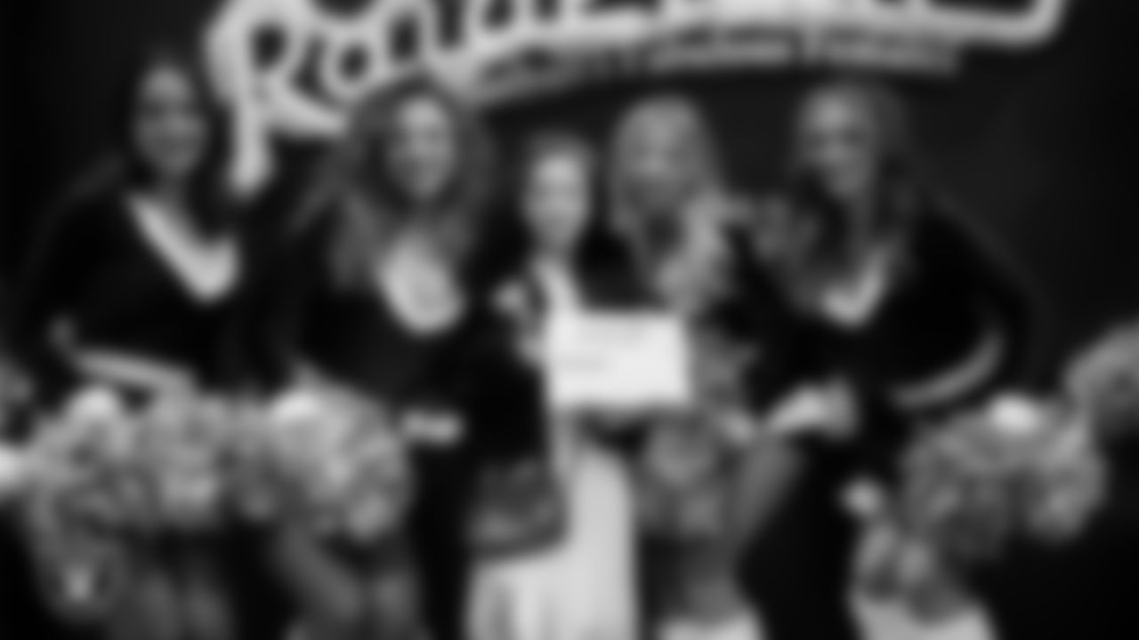 Raiderettes pose for a photo with a Junior Raiderette during the Junior Raiderettes Banquet at The Studio.