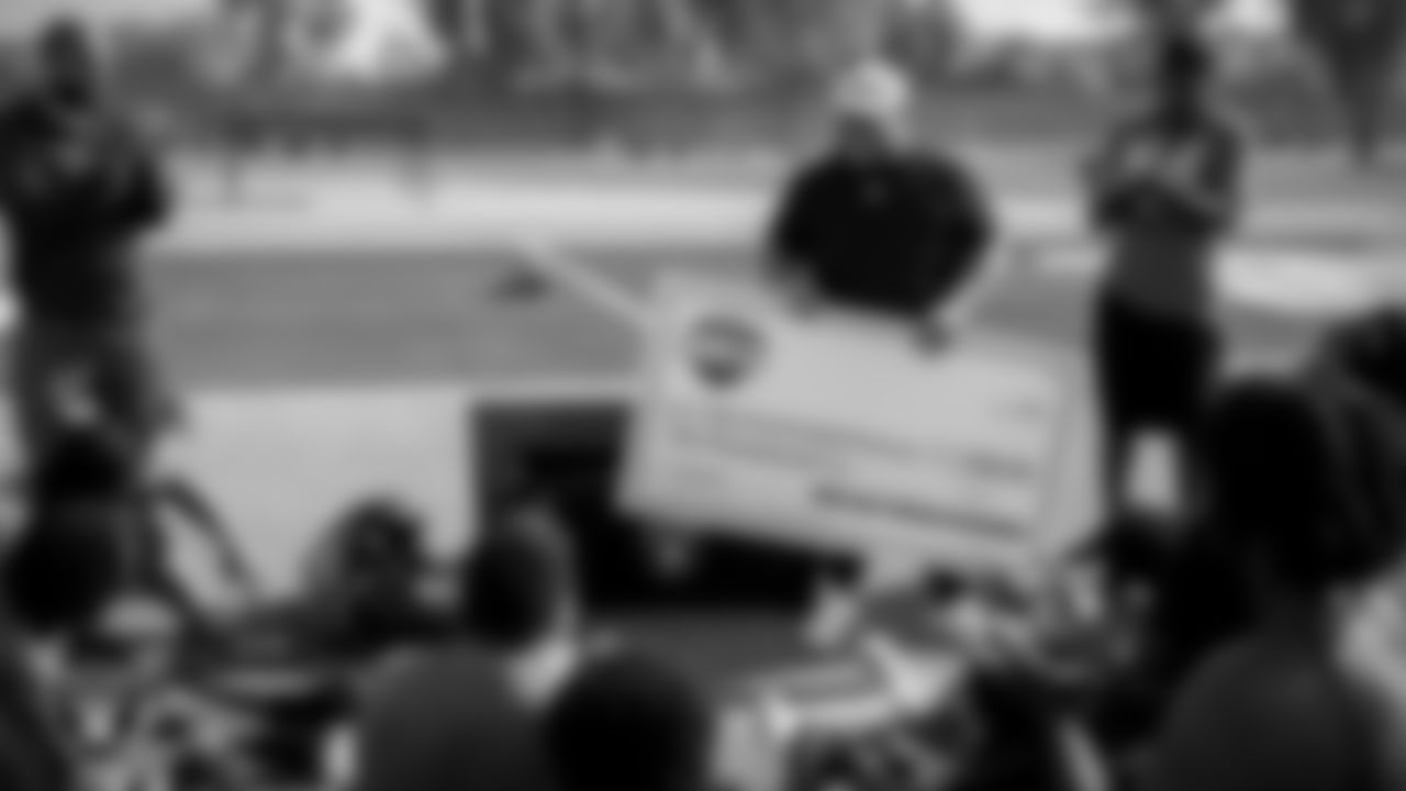 Las Vegas Raiders senior manager of football development Jordan Aguilar presents the Canyon Springs High School football team with a donation check during practice at Canyon Springs High School.