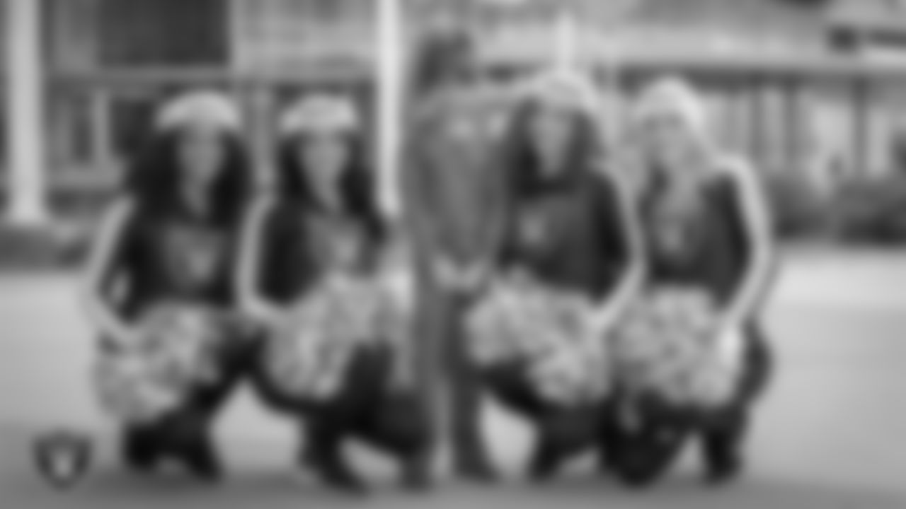 Raiderettes Shayla, Sloane, Lexie and Kennedy pose for a photo with an attendee during a toy drive at Intermountain Health Primary Children's Hospital.