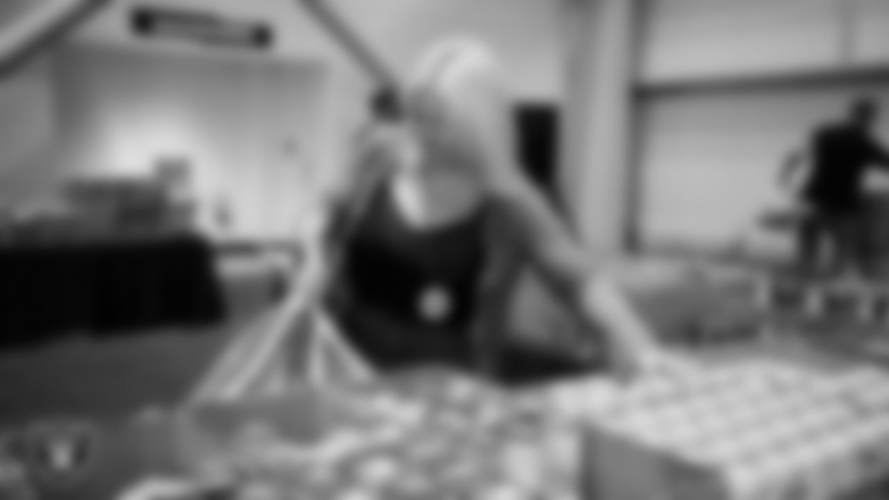 Las Vegas Raiders staff members help pack meals during the Raiders Holiday Meal Packing Party at Intermountain Health Performance Center.