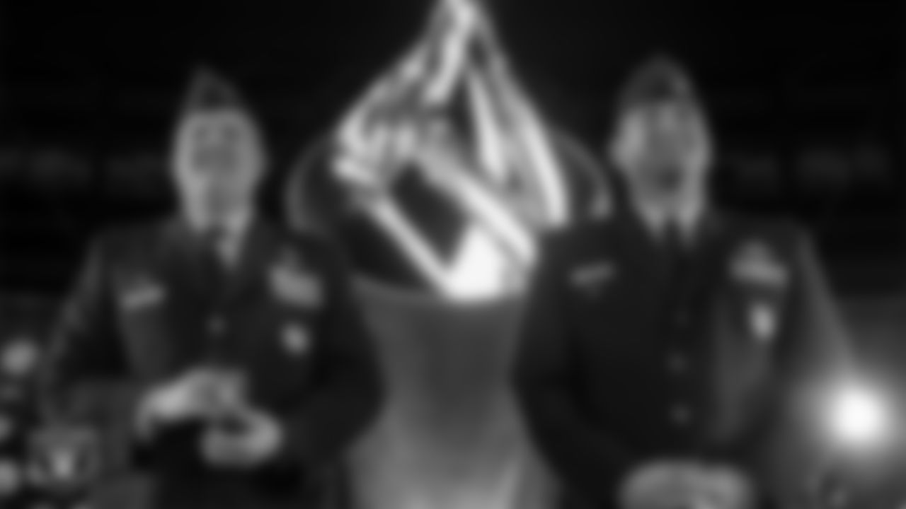 Nellis Air Force Airmen Colonel Jason J. Glynn and Colonel Ethan E. Sabin light the Al Davis Memorial Torch before the Las Vegas Raiders' regular season home game against the Dallas Cowboys at Allegiant Stadium.