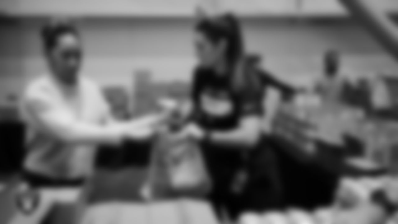 Las Vegas Raiders staff members help pack meals during the Raiders Holiday Meal Packing Party at Intermountain Health Performance Center.