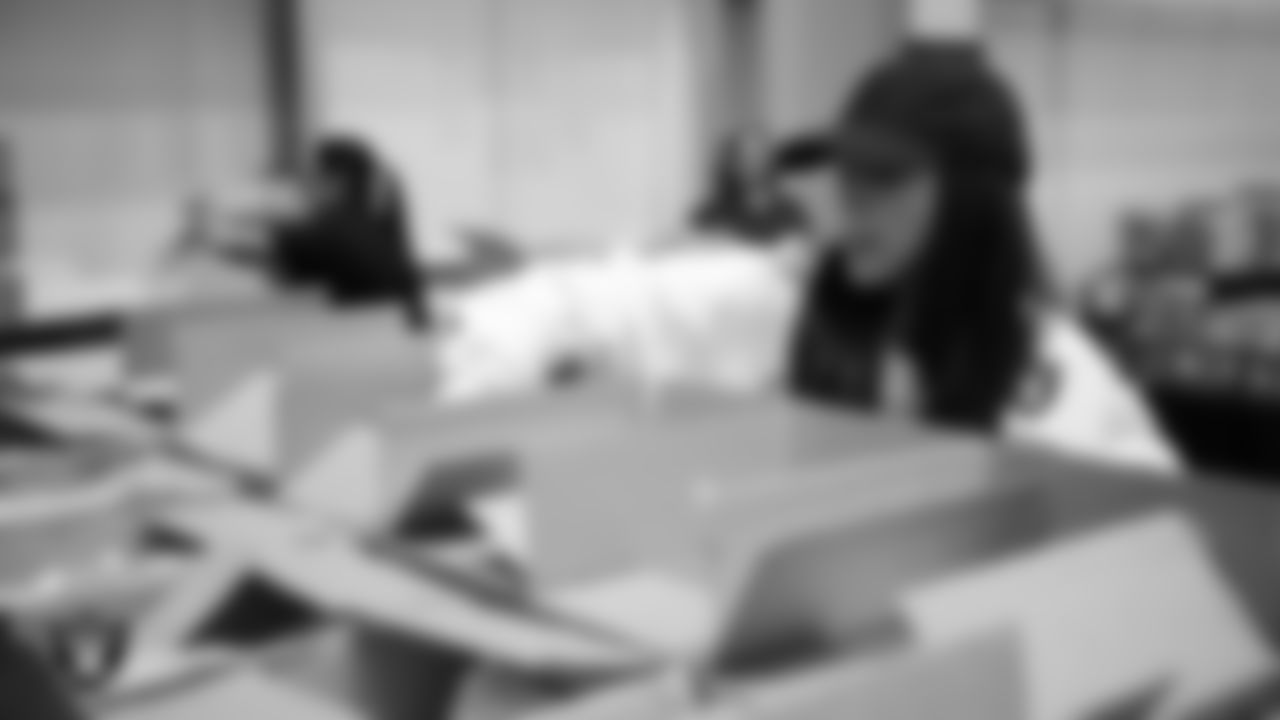 Las Vegas Raiders staff members help pack meals during the Raiders Holiday Meal Packing Party at Intermountain Health Performance Center.