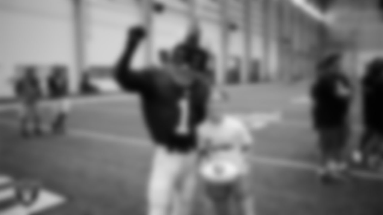 Raider Rusher poses for a photo with an athlete at a skills camp during Play Football Day at Intermountain Health Performance Center.