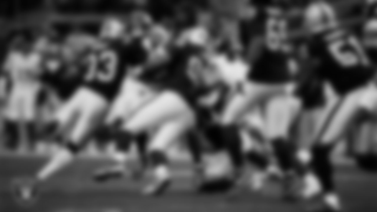 Las Vegas Raiders linebacker Jamal Adams (33) and defensive tackle Jonah Laulu (96) make a tackle during the regular season home game against the New York Giants at Allegiant Stadium.