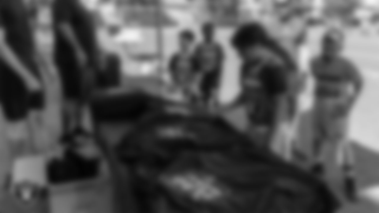 An athlete receives Las Vegas Raiders gear during Silver and Black Saturday at Bill and Lillie Heinrich YMCA.