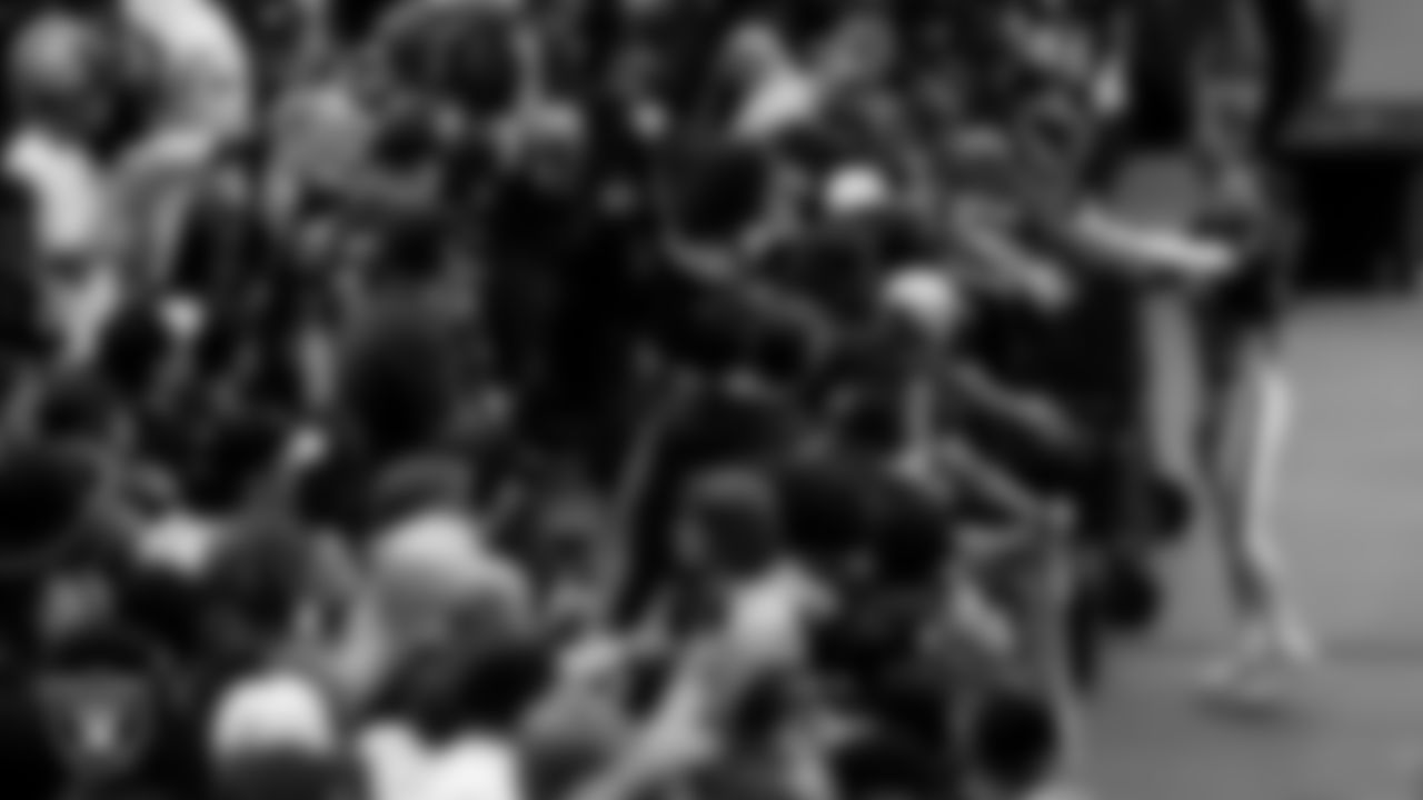 Las Vegas Raiders defensive end Maxx Crosby (98) high-fives fans during a 2025 Training Camp mock game at Allegiant Stadium.