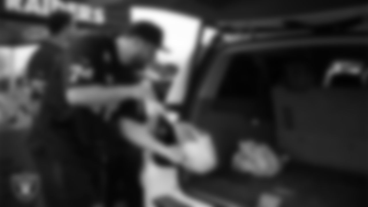 Las Vegas Raiders tackle Kolton Miller (74) helps distribute Thanksgiving meals to families during Turkey Time with the O-Line at Allegiant Stadium.