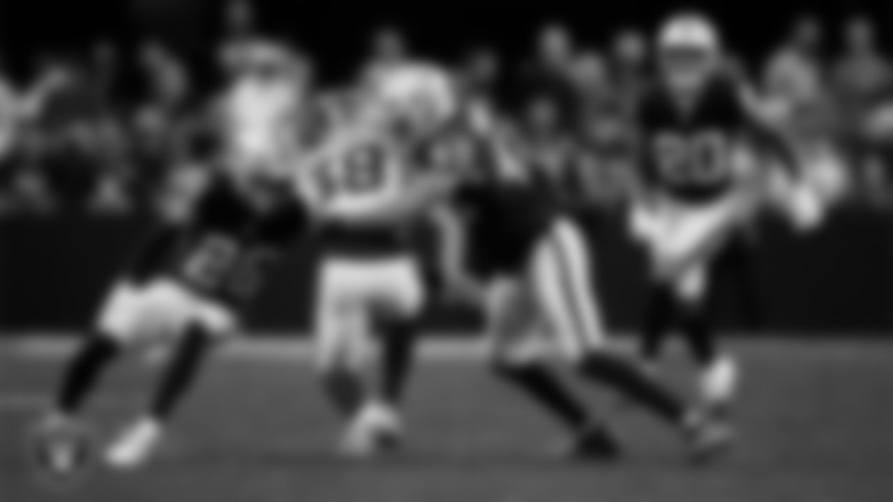 Las Vegas Raiders cornerback Darien Porter (26) and defensive end Charles Snowden (49) make a tackle during the regular season home game against the Denver Broncos at Allegiant Stadium.