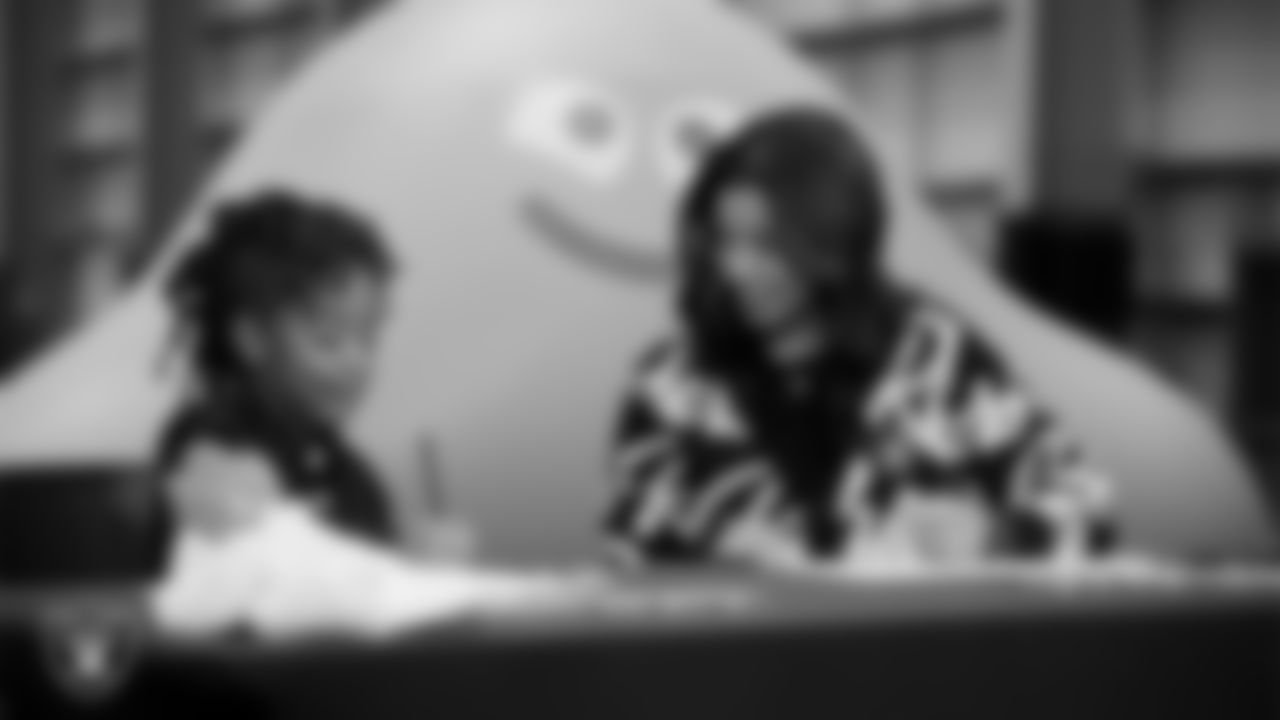 Las Vegas Raiders President Sandra Douglass Morgan designs custom shoes for My Cause My Cleats with Intermountain Children's Health patient Evelyn at Intermountain Health Performance Center.