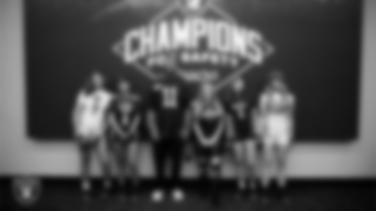 Las Vegas Raiders safety Jeremy Chinn (11) and Ellie Naqvi from Naqvi Injury Law pose with athletes from Chaparral High School and Clark High School showing off their new uniforms and equipment at Intermountain Health Performance Center.