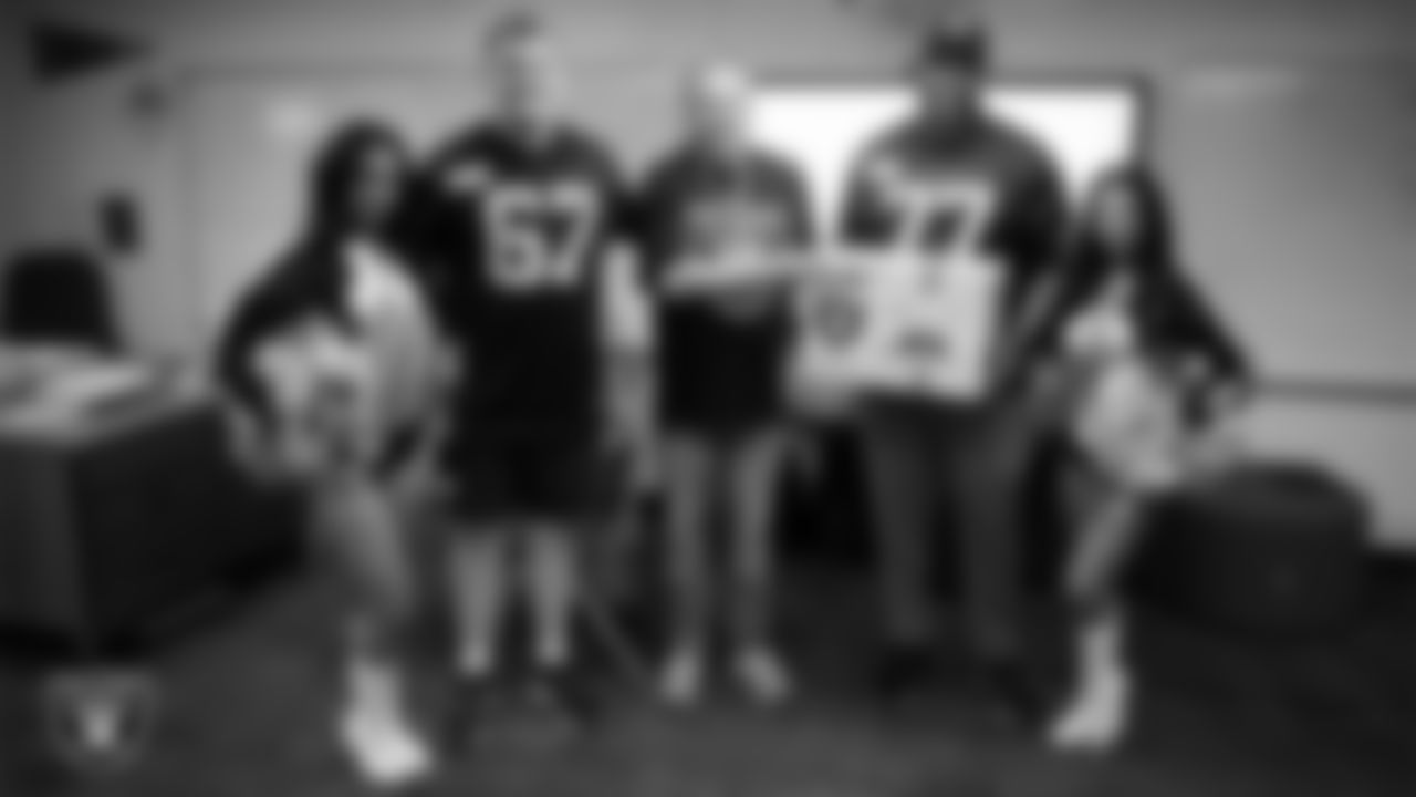 Raiderettes Cierra and Kylee and Las Vegas Raiders center Will Putnam (67) and tackle Thayer Munford Jr. (77) pose for a photo with a teacher while celebrating Teacher Appreciation Week at Matt Kelly Elementary School.