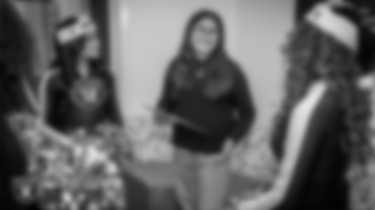 Raiderettes Sloane and Lexie with an attendee during a toy drive at Intermountain Health Primary Children's Hospital.