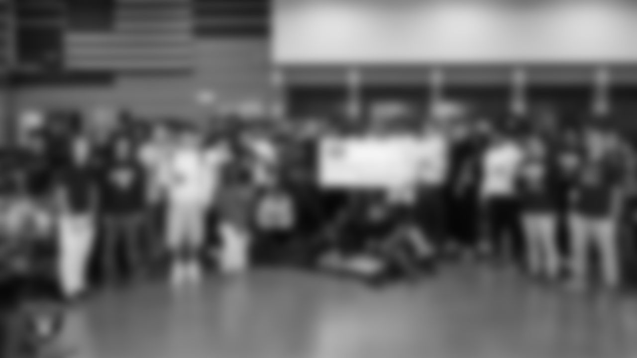 Spring Valley High School football coach Eric Dyer and his team pose for a photo with the Tom Flores Coach of the Week award after practice at Spring Valley High School.