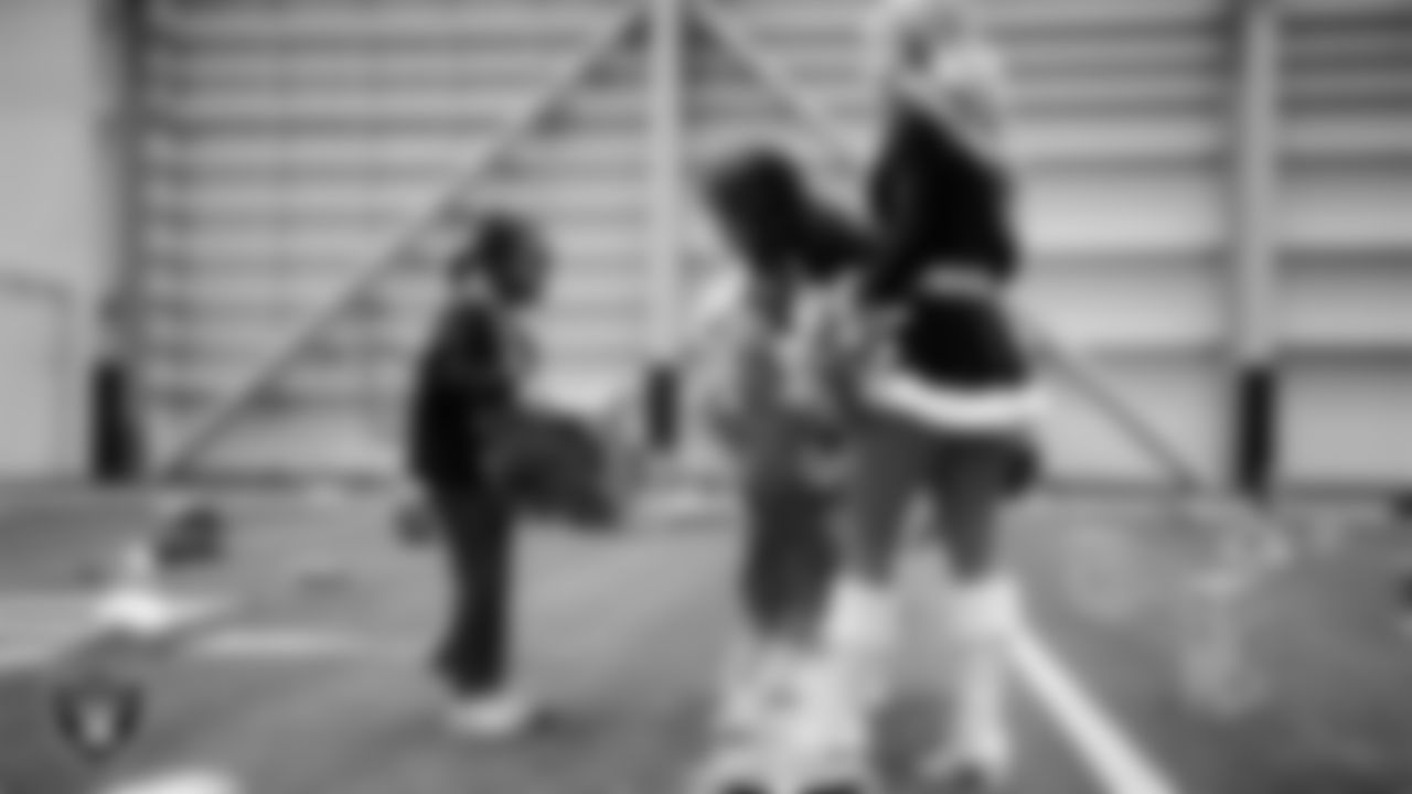 Raiderettes Annalise and Ali help a student select toys during a Raiders Youth Holiday Party at Intermountain Health Performance Center.