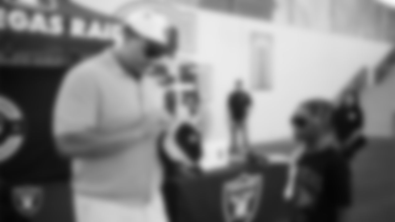 Las Vegas Raiders guard Caleb Rogers (76) signs an autograph before the Raiders' Football Showcase game at Canyon Springs High School.