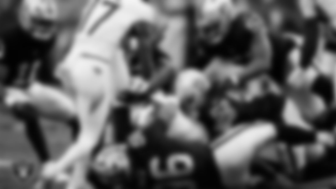 Las Vegas Raiders defensive tackle Jonah Laulu (96) and linebacker Elandon Roberts (52) make a tackle during the regular season home game against the Tennessee Titans at Allegiant Stadium.