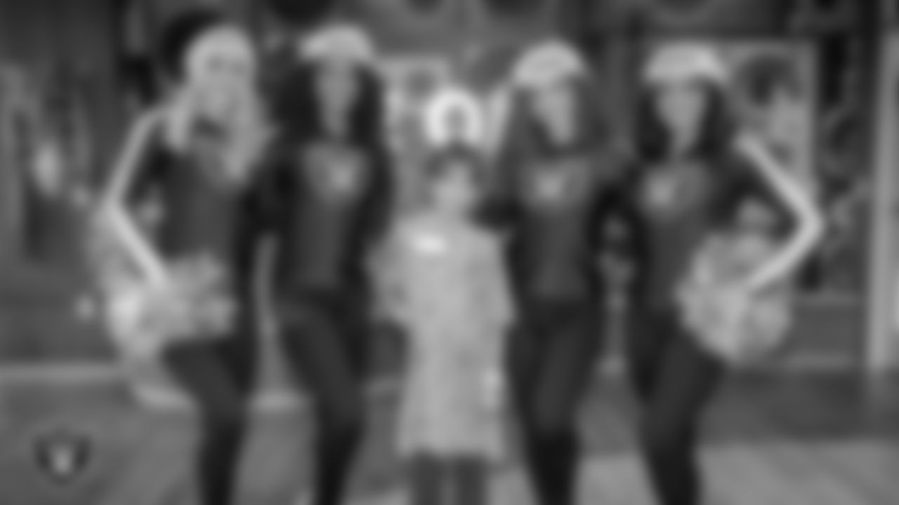 Raiderettes Kennedy, Shayla, Lexie and Sloane pose for a photo with an attendee during a toy drive at Intermountain Health Primary Children's Hospital.