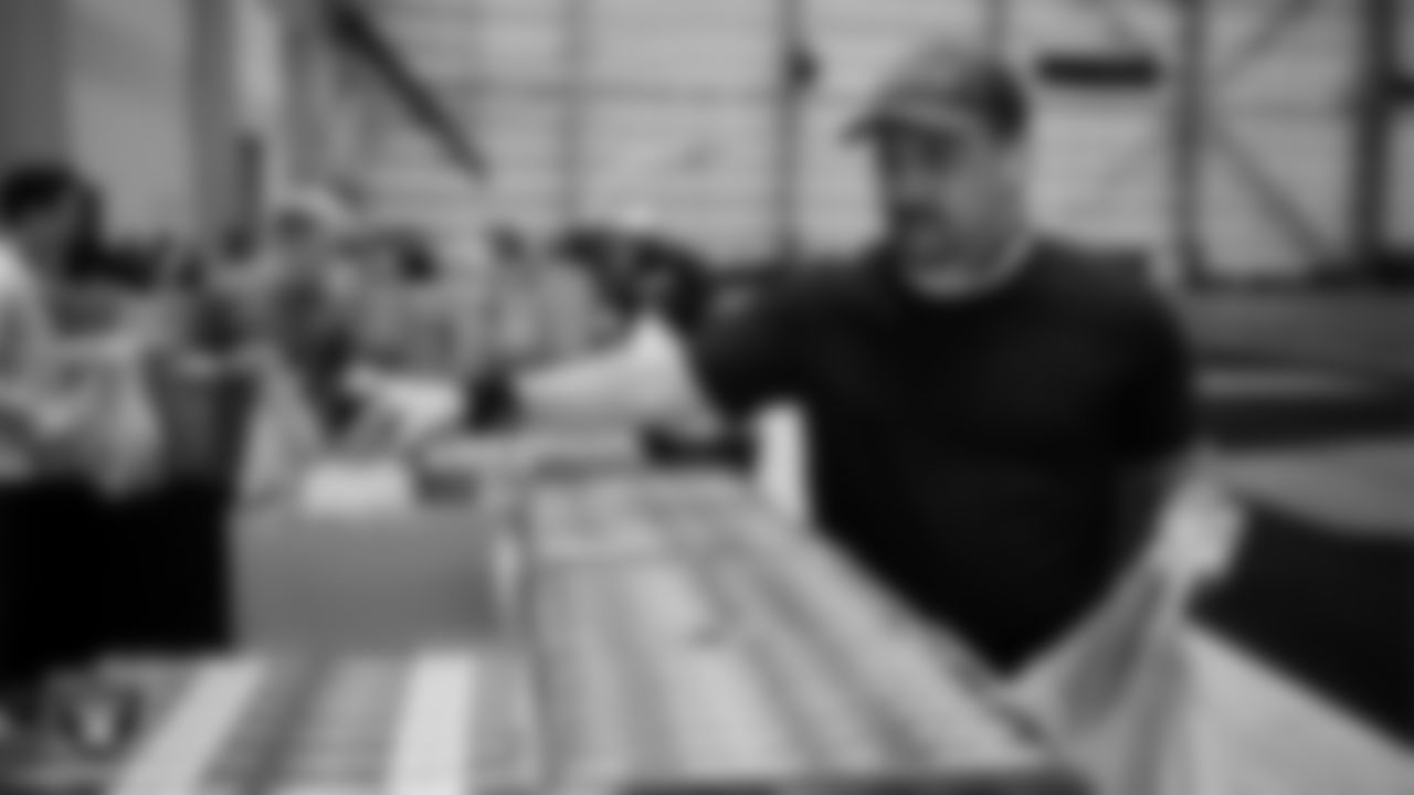 Las Vegas Raiders staff members help pack meals during the Raiders Holiday Meal Packing Party at Intermountain Health Performance Center.