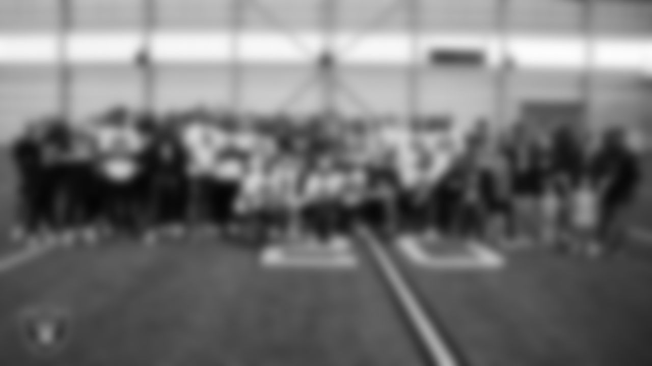 Christopher Arias and Marcos Carrillo and their families from Make-A-Wish pose for a photo with the Las Vegas Raiders after practice during a visit to Intermountain Health Performance Center.