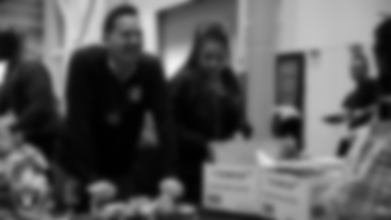 Las Vegas Raiders staff members help pack meals during the Raiders Holiday Meal Packing Party at Intermountain Health Performance Center.