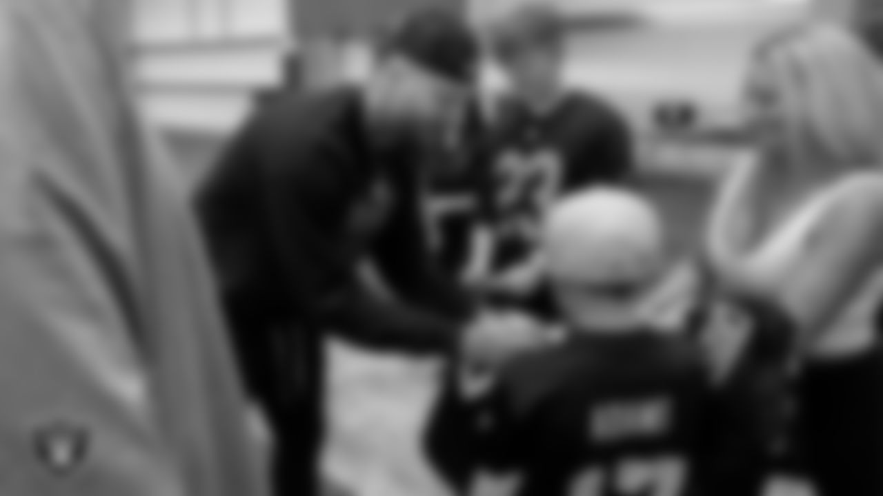 Clay Charlson from the Make-A-Wish Foundation gets his jersey signed by Las Vegas Raiders defensive end Maxx Crosby (98) during a visit to Intermountain Health Performance Center.