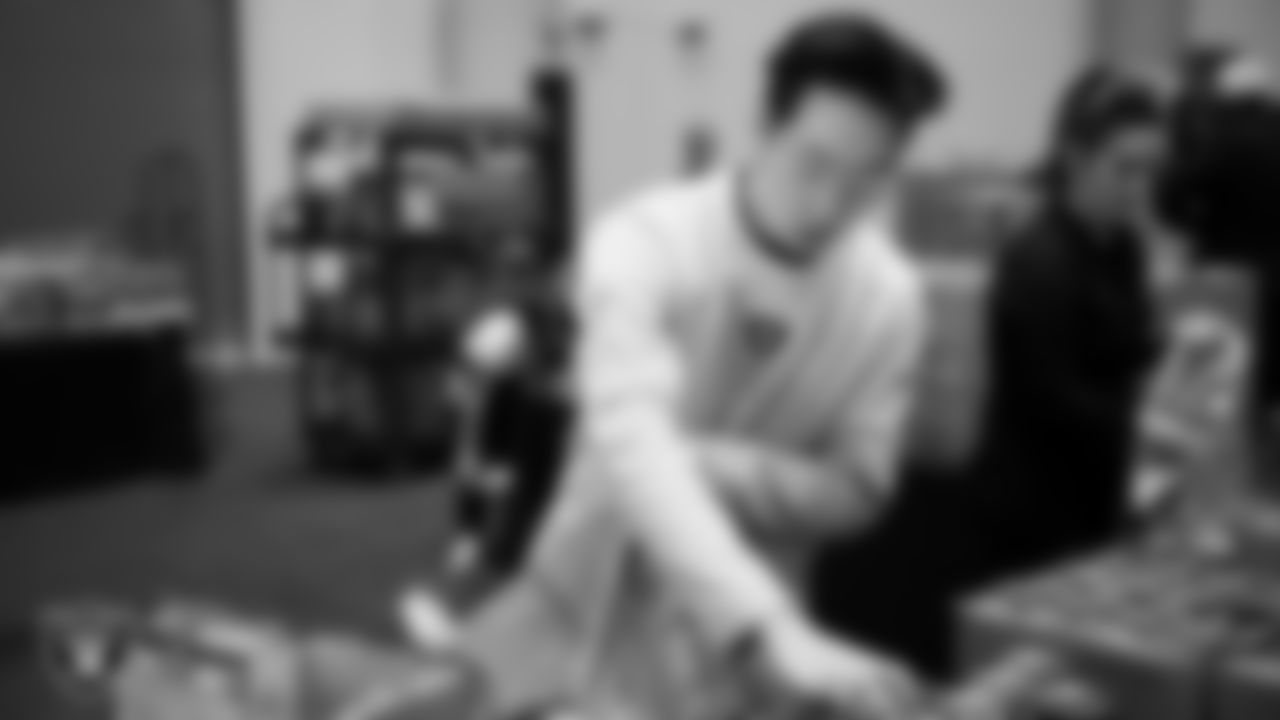 Las Vegas Raiders staff members help pack meals during the Raiders Holiday Meal Packing Party at Intermountain Health Performance Center.