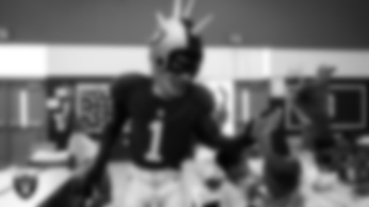 Raider Rusher gives a high-five to a student during a 'Lil Raiders Pop-Up at Matt Kelly Elementary School.