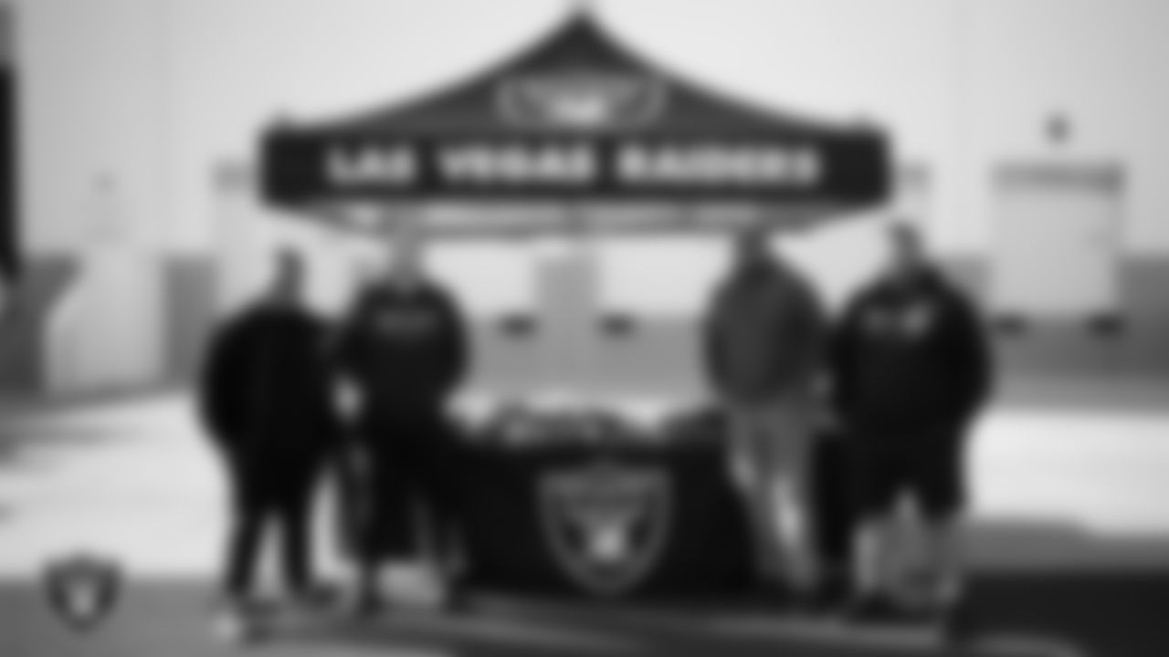 Las Vegas Raiders senior manager of football development Jordan Aguilar poses for a photo with members of the Western High School football coaching staff during the football development equipment giveaway at Las Vegas Raiders Headquarters.